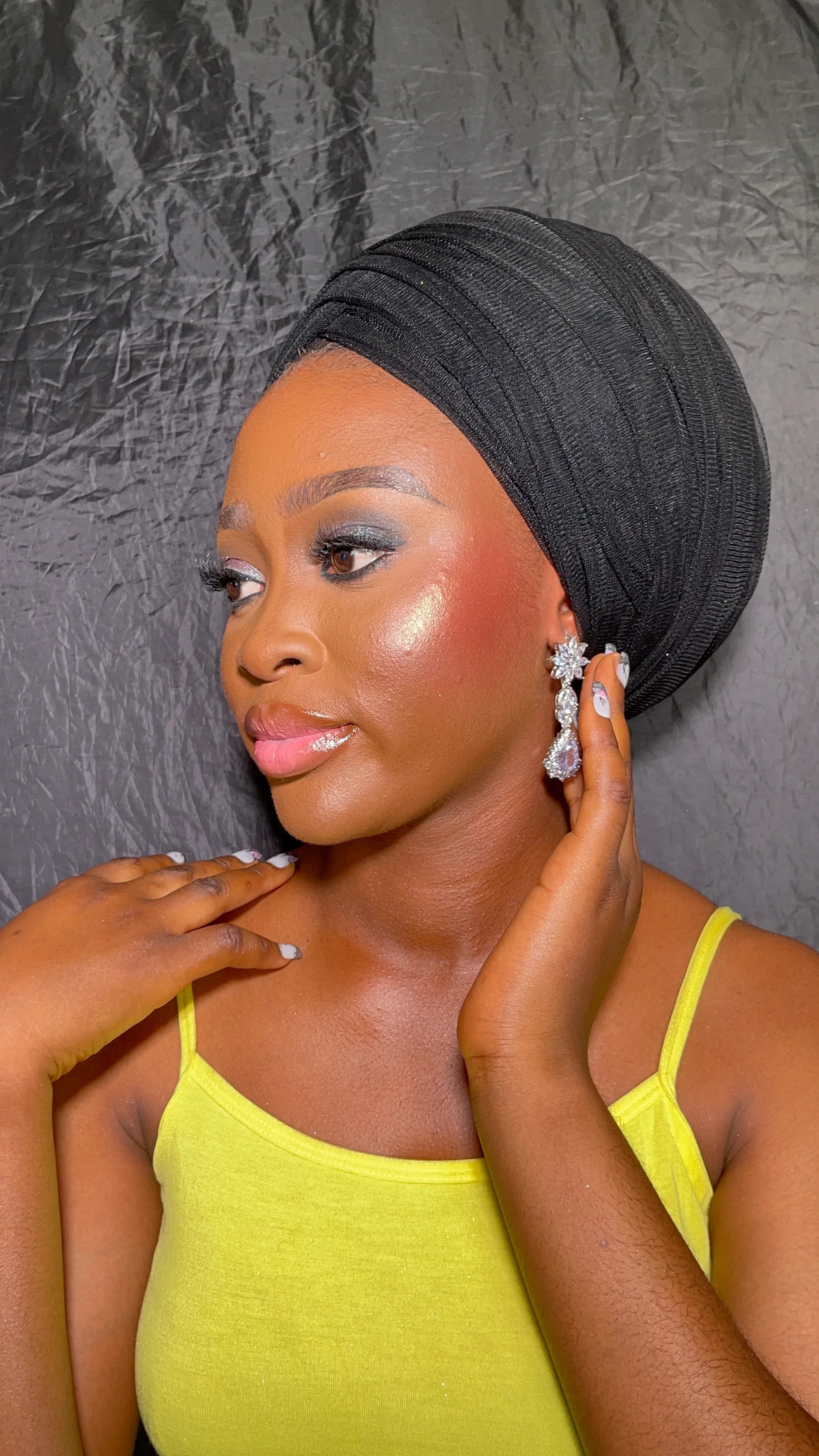 Editorial makeup close-up with a black gele headwrap