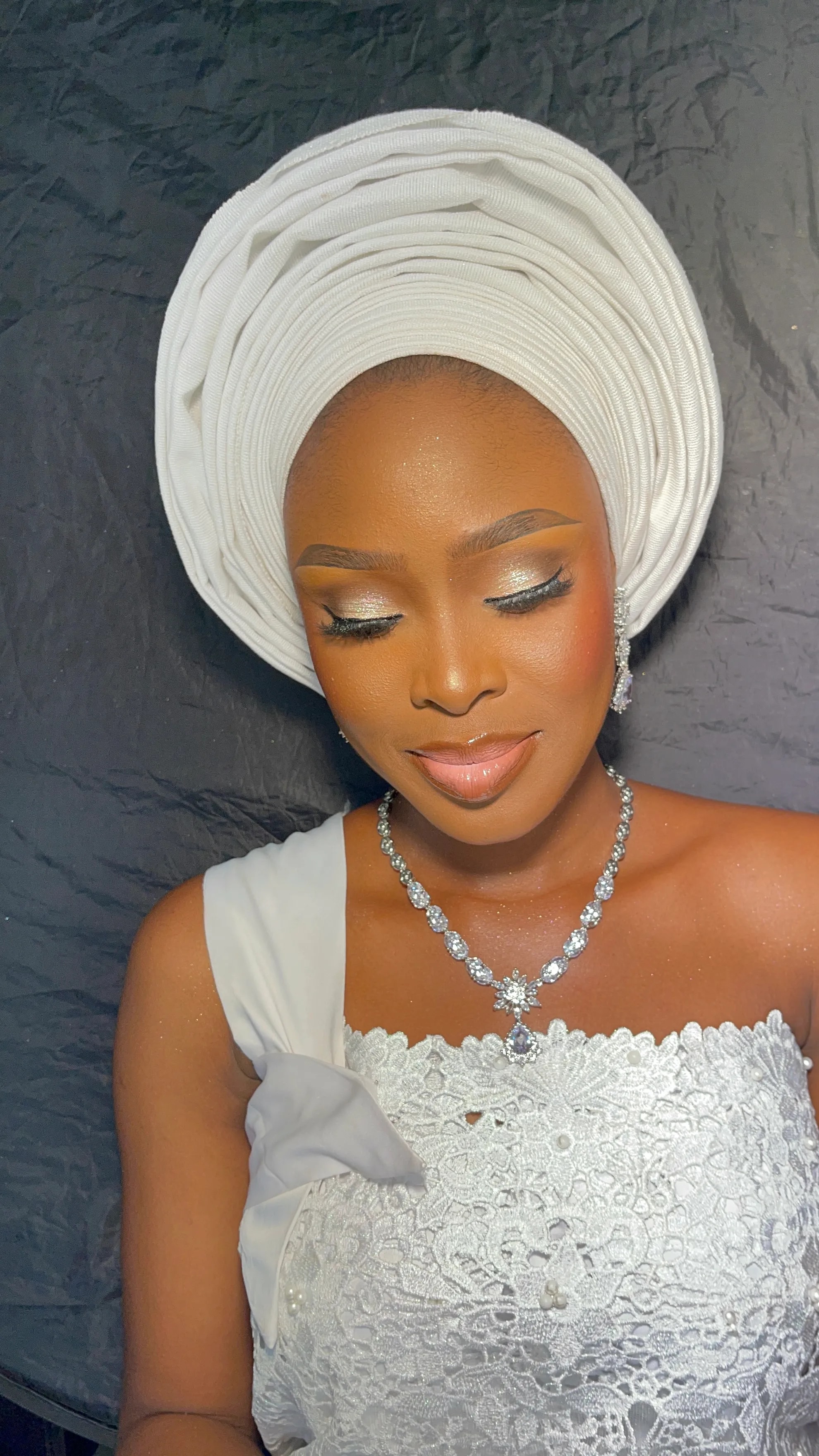 Bridal makeup with a white gele headwrap